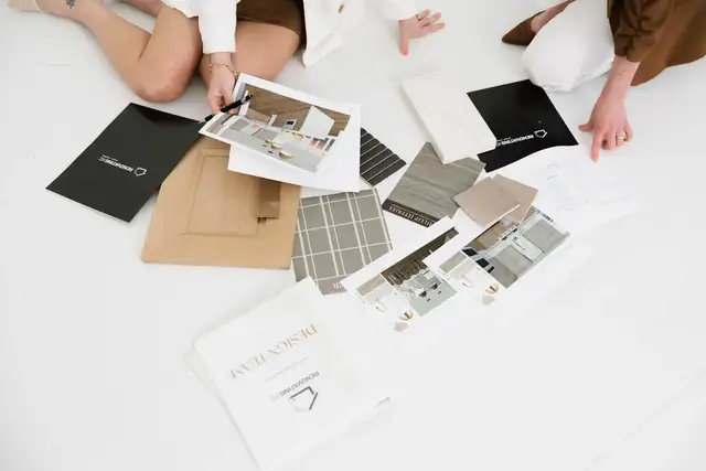 Renovating KC designers laying out a design board with cabinet, tile and countertop samples